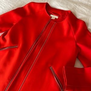 Bright orange crepe king jacket with gold zipper detailing.